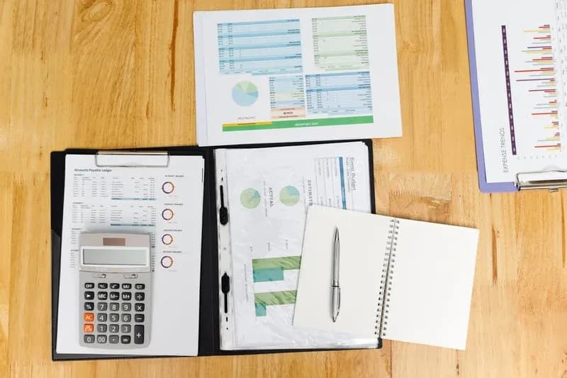 Bookkeeping desk with financial reports, calculator, and expense charts — Basic Bookkeeping Plan from RDP Bookkeeping Solutions